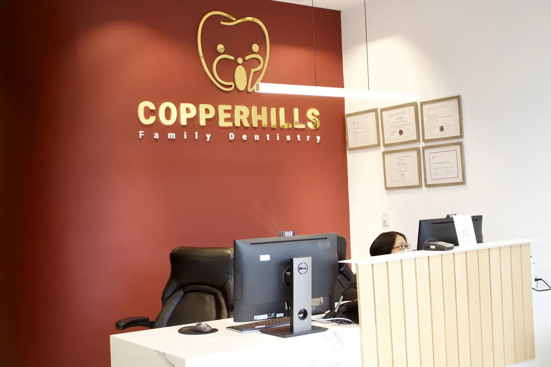 The reception desk and gold logo wall at Copperhills Family Dentistry
